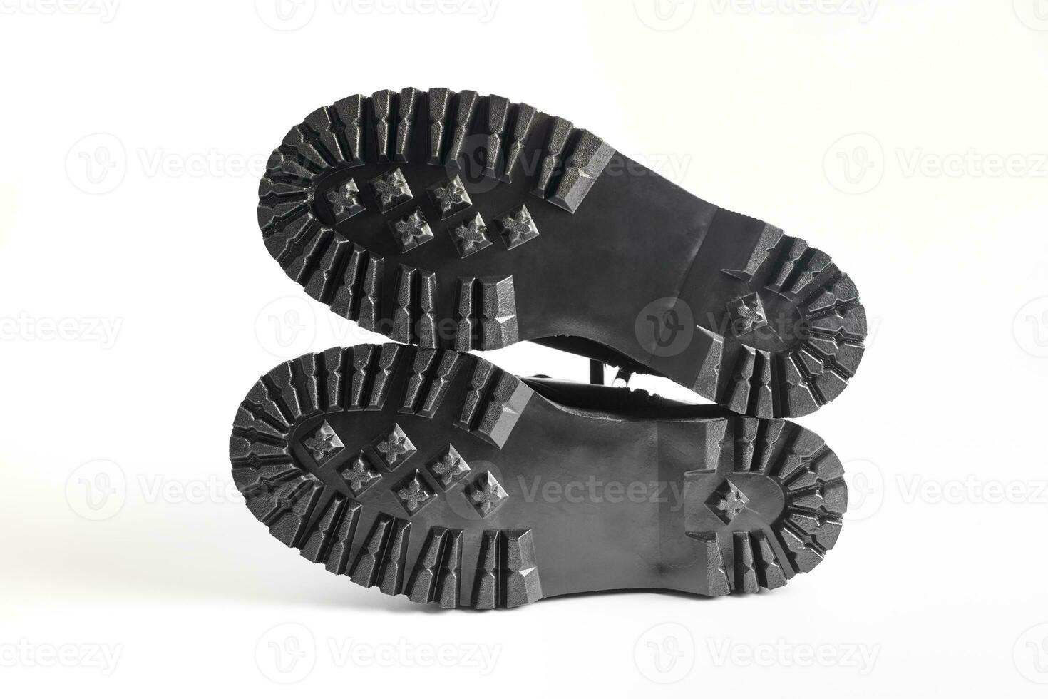 Lug soles of black combat boots on high heel platform lying on isolated white background photo