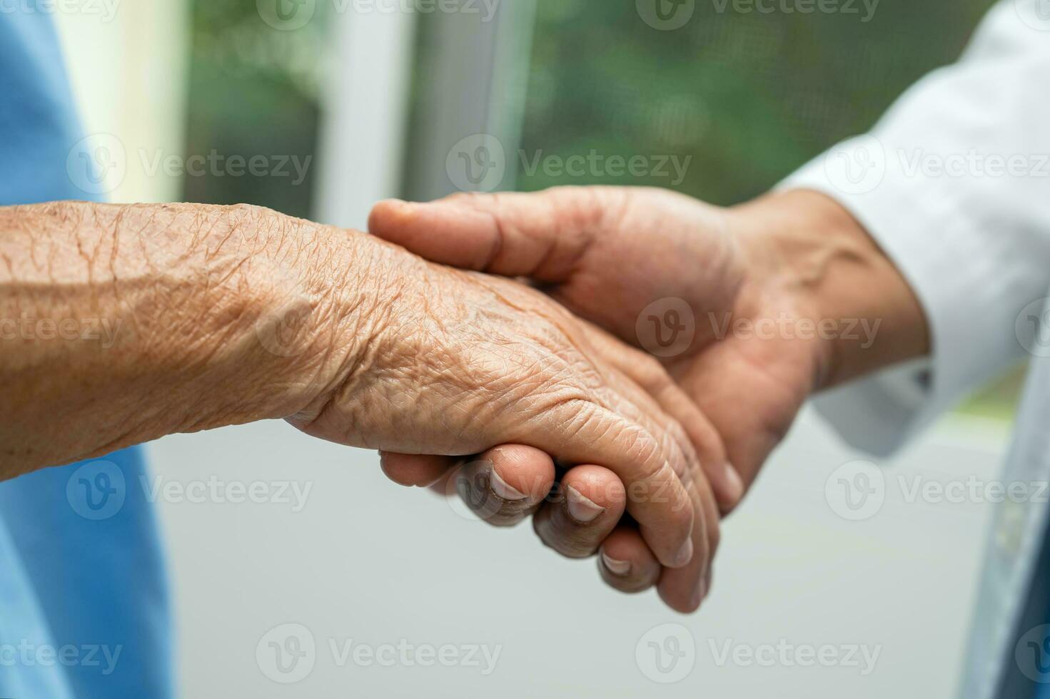 Caregiver holding hands Asian elderly woman patient with love, care, encourage and empathy at nursing hospital, healthy strong medical concept. photo