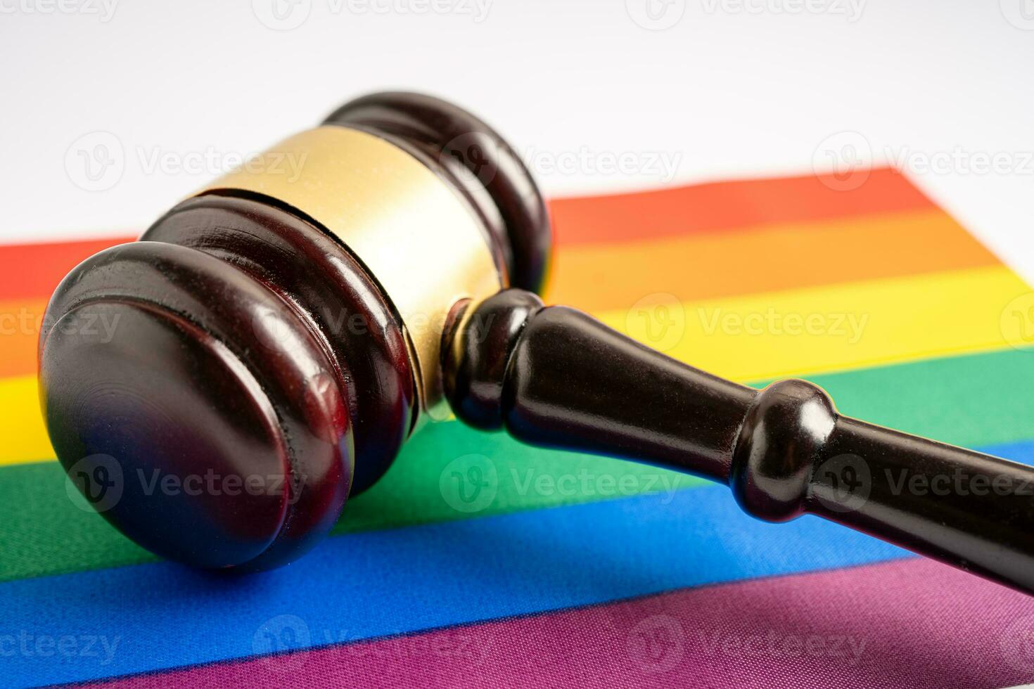 martillo para juez abogado en la bandera del arco iris, símbolo del mes del orgullo lgbt celebran anualmente en junio las redes sociales de gays, lesbianas, bisexuales, transgénero, derechos humanos. foto