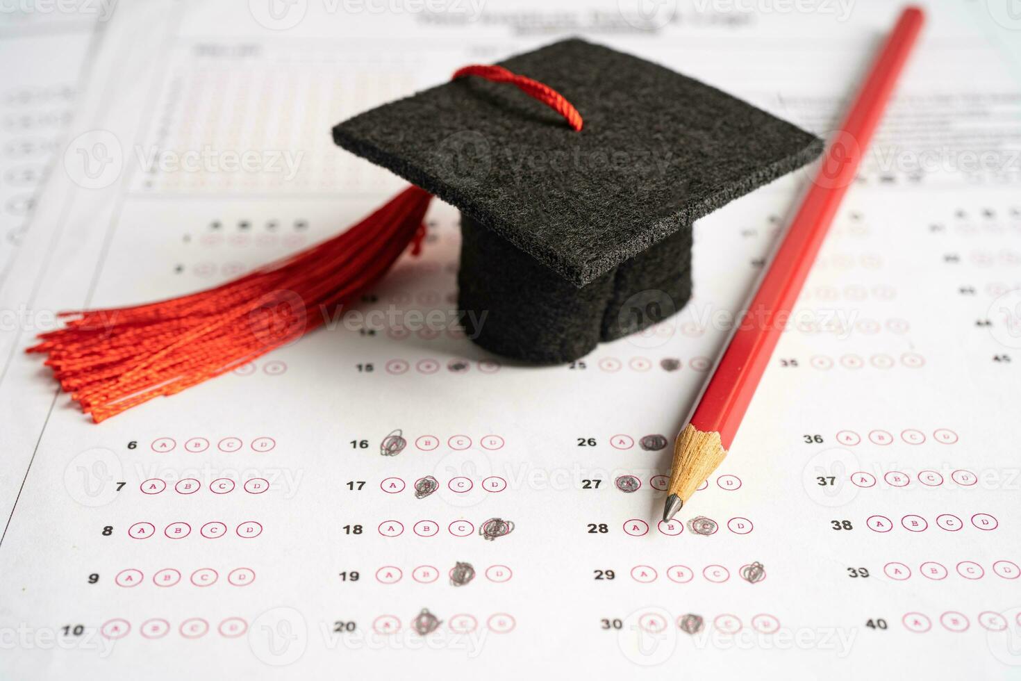 Graduation gap hat and pencil on answer sheet background, Education study testing learning teach concept. photo