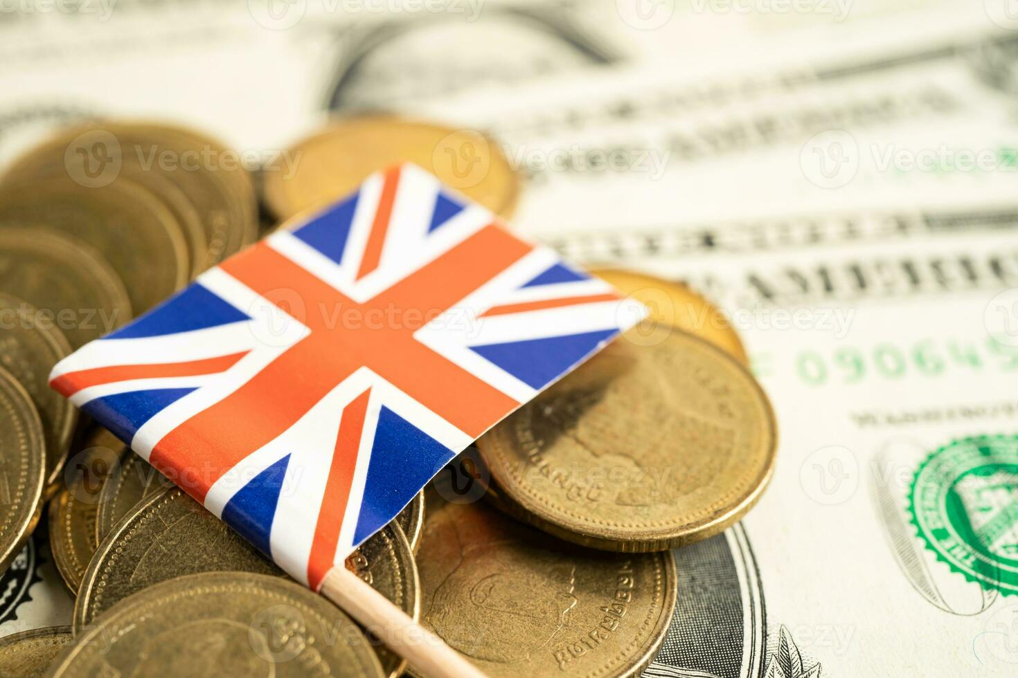 Stack of coins with United Kingdom flag and US dollar banknotes. photo