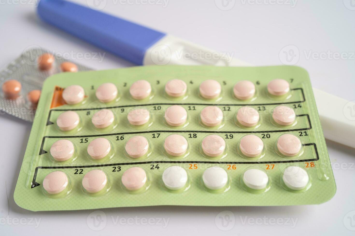 Pregnancy test and birth control pills on calendar, contraception health and medicine. photo