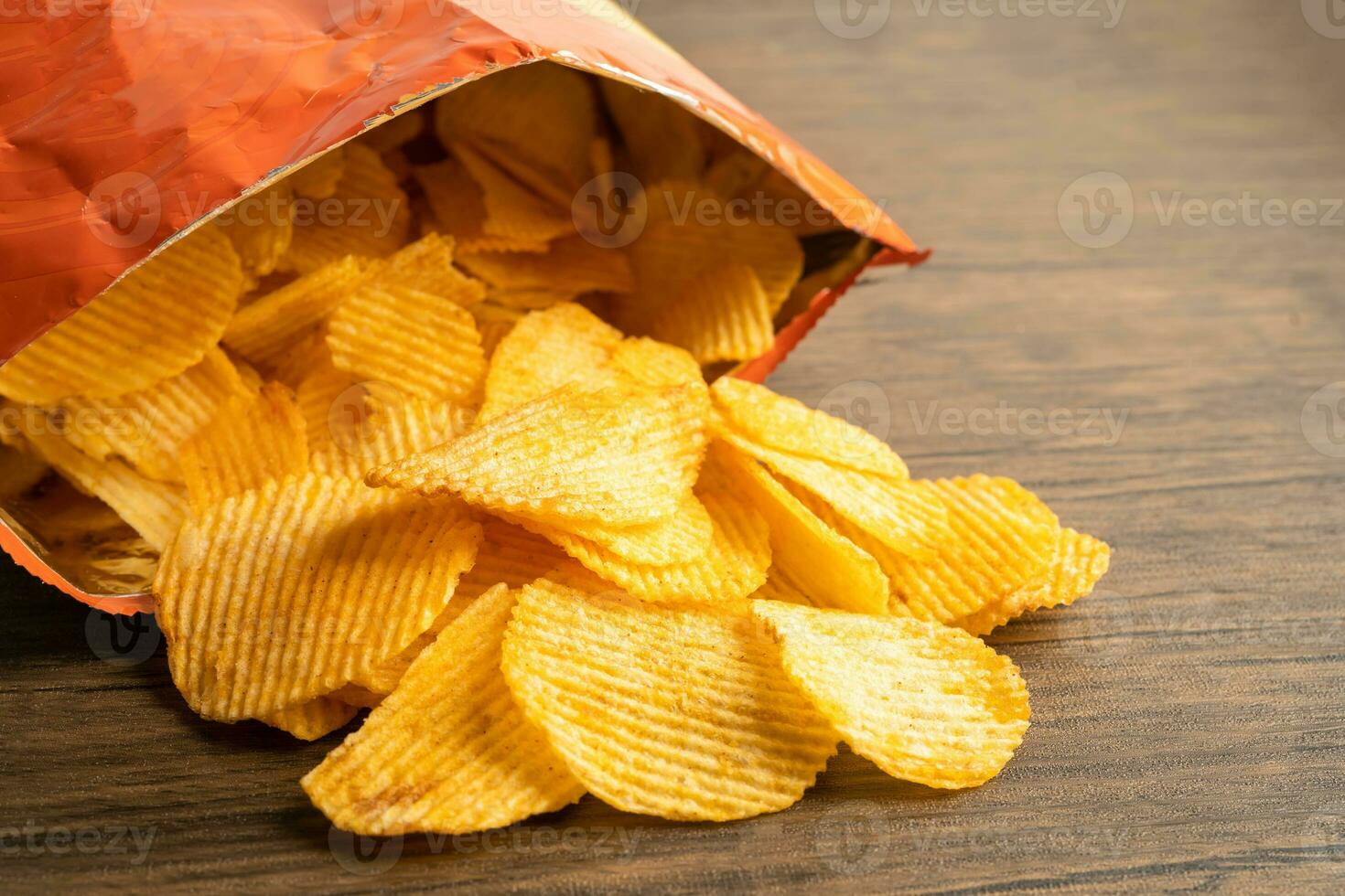 Potato chips, delicious BBQ seasoning spicy for crips, thin slice deep fried snack fast food in open bag. photo