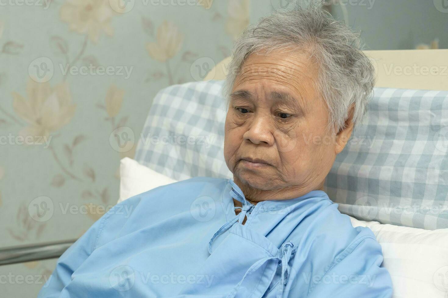 Asian elderly woman patient smile bright face with strong health while lying on bed in hospital, healthy strong medical concept. photo