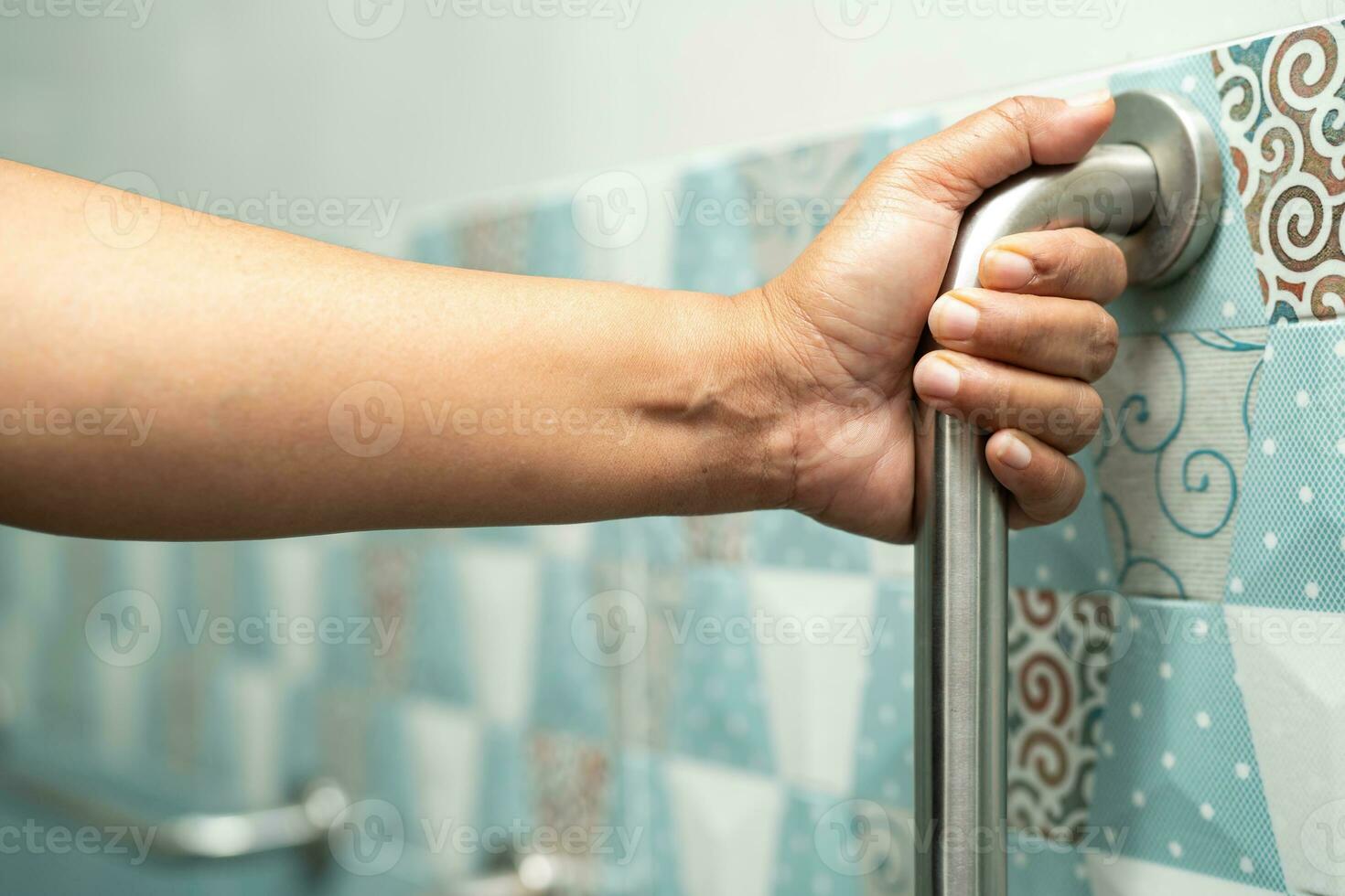 Asian elderly woman use bathroom handle security in toilet, healthy strong medical concept. photo