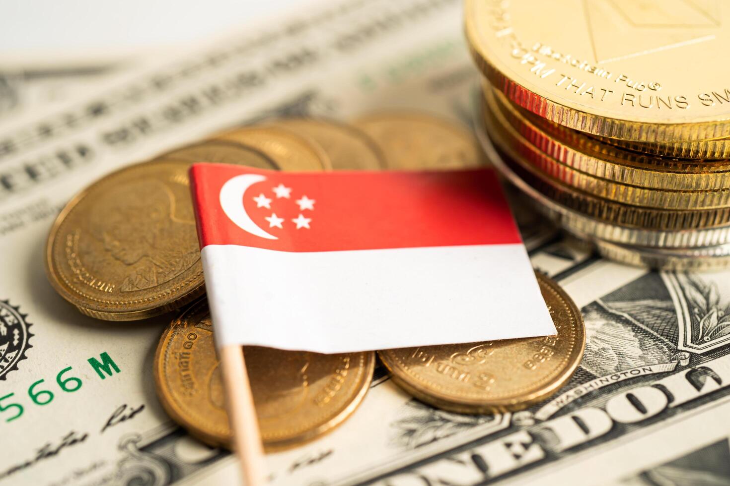 Stack of coins with Singapore flag and US dollar banknotes. photo