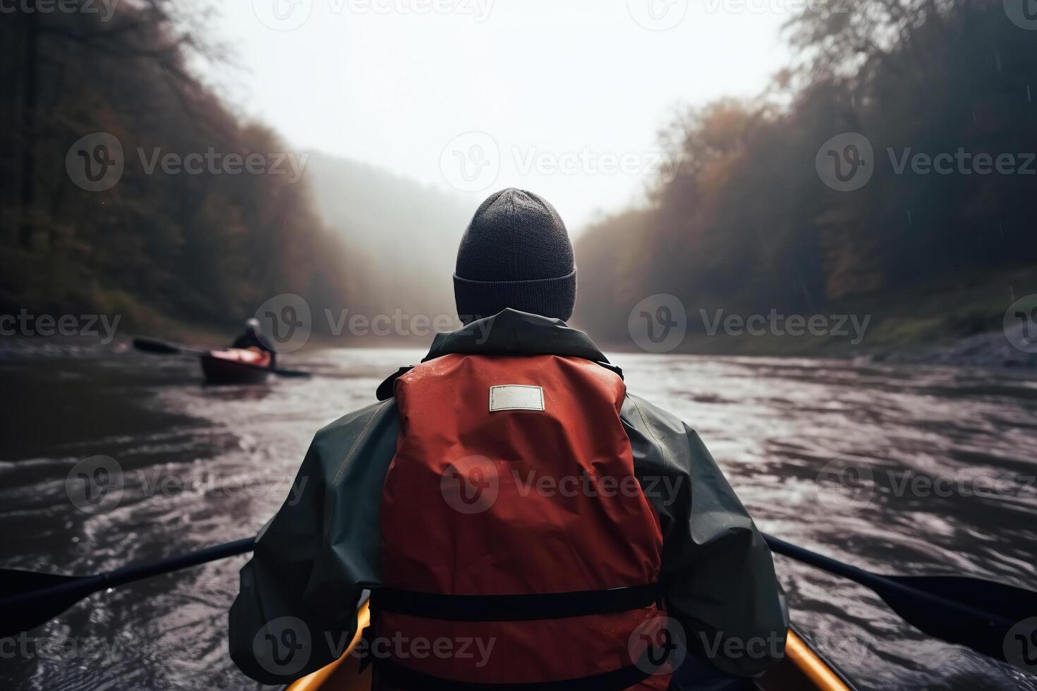 Rafting on river in autumn. Rear view of male athlete in kayak with paddles on water on an autumn cloudy day, active recreation. photo