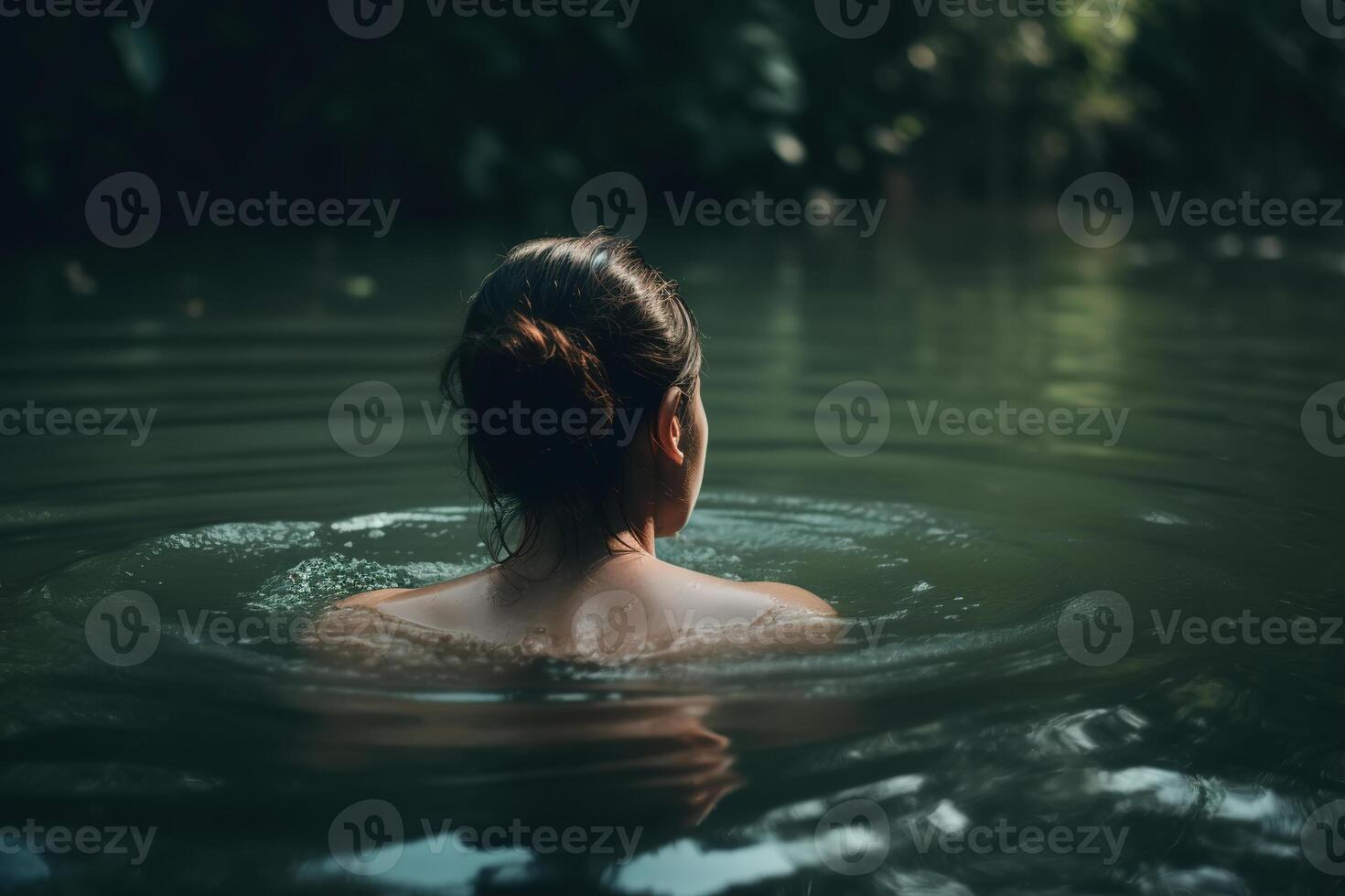 Wild swimming, rest recovery, water relaxation concept. Rear view of caucasian brunette woman floating in pond in nature, close-up. photo