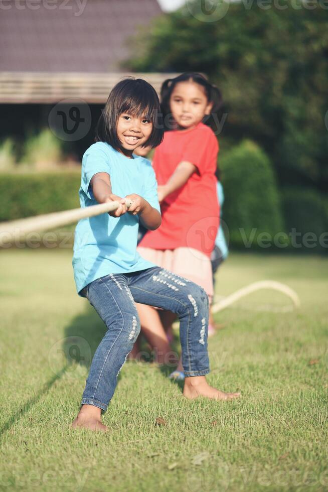 Children group playing tug of war at the park photo