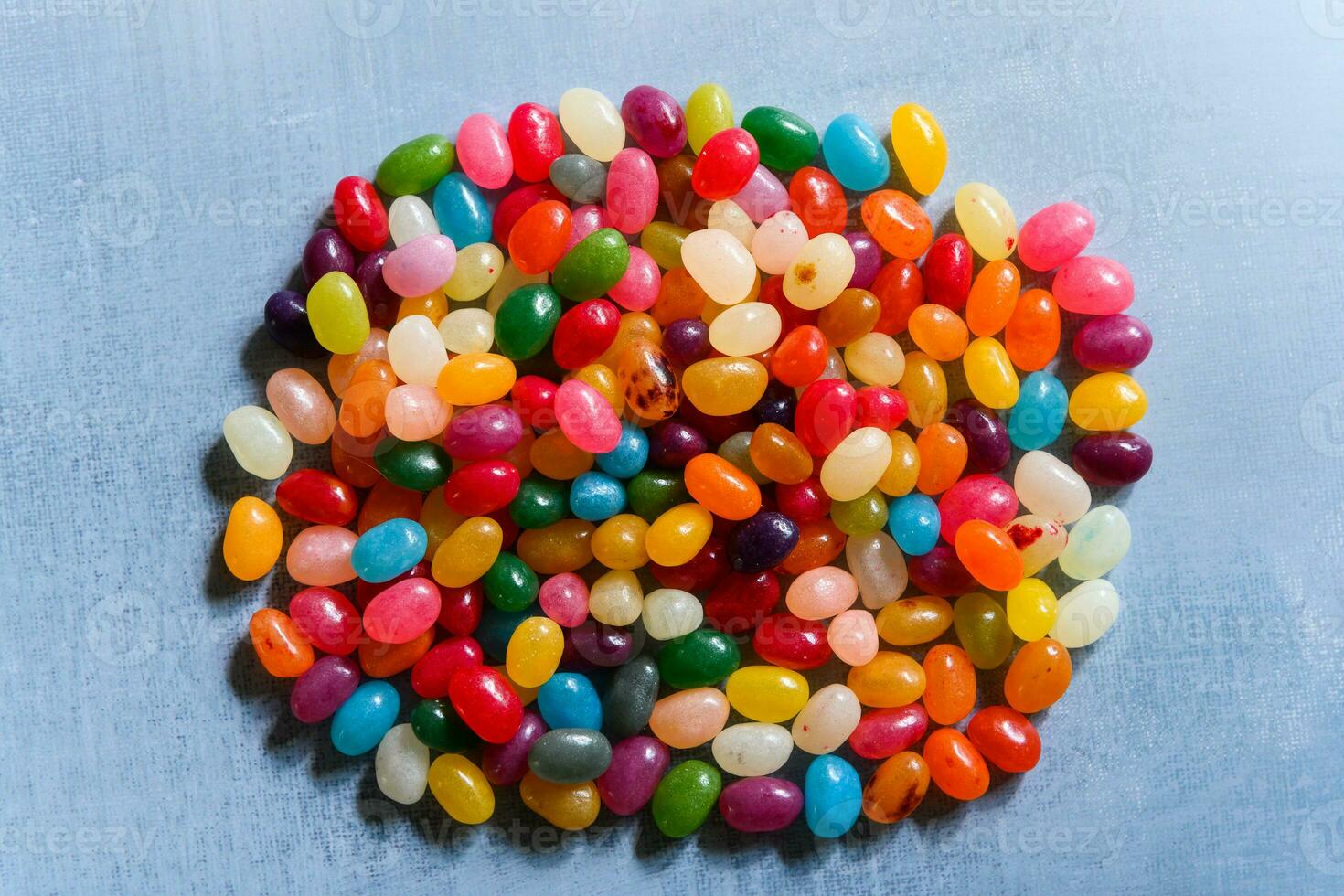 Big round pile of colorful jellybeans on rustic grey background photo