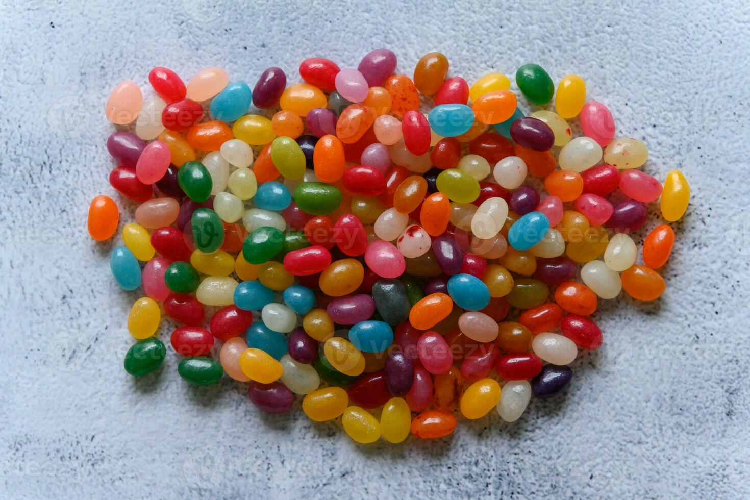 Big round pile of colorful jellybeans on rustic grey background photo