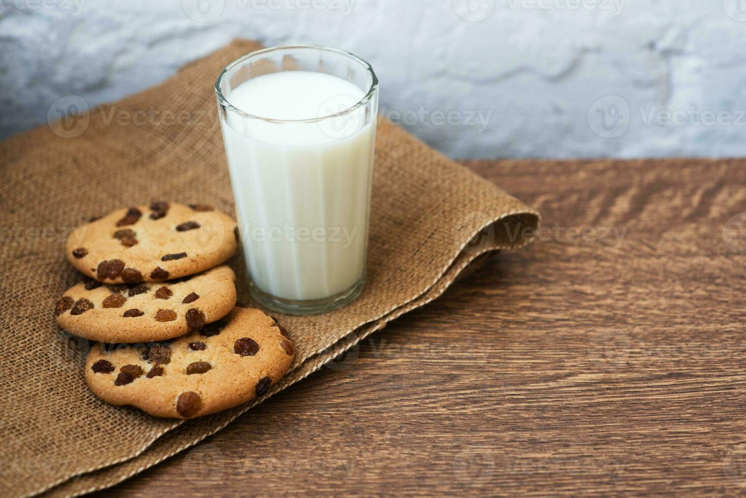 Fragrant, tasty, homemade cookies with raisins and a glass of fresh milk on the table photo