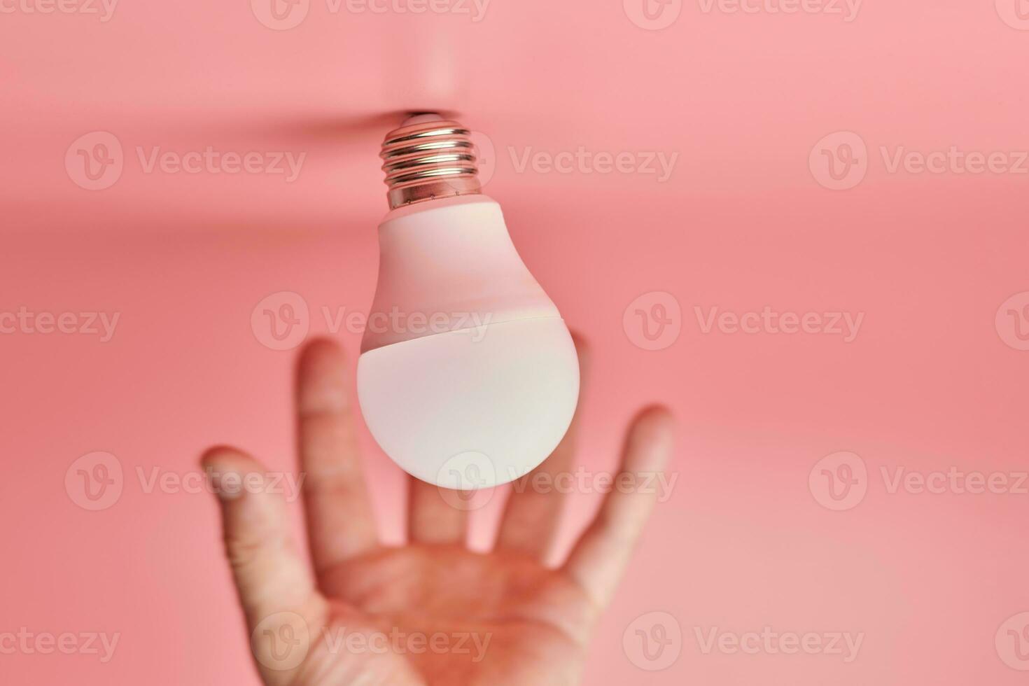 Light bulb and hand, idea catching concept. Symbol of new events or finding solutions to problems. Creative minimal innovations. photo