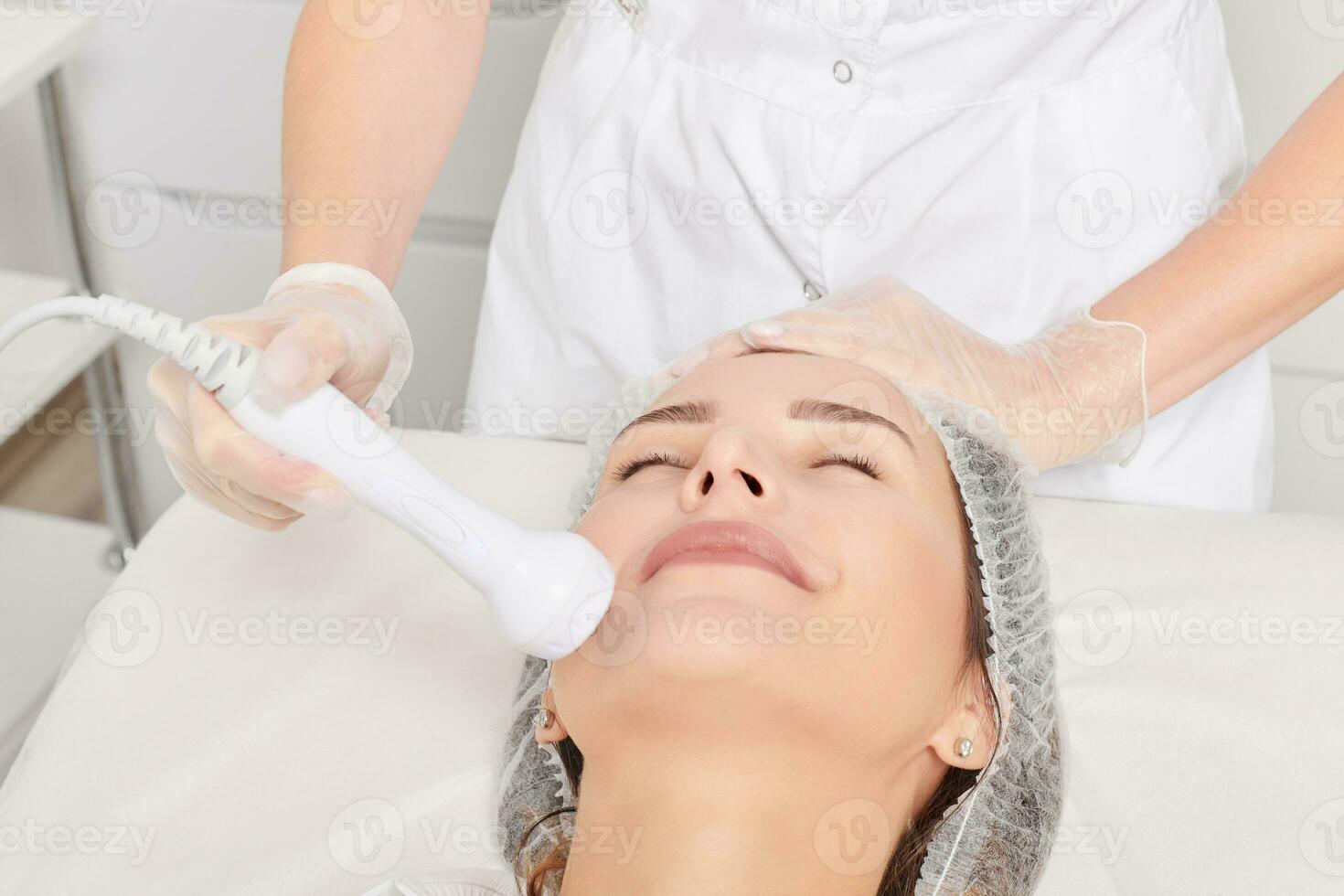 Beautician makes RF lifting for rejuvenation woman face, anti aging cosmetic procedure photo