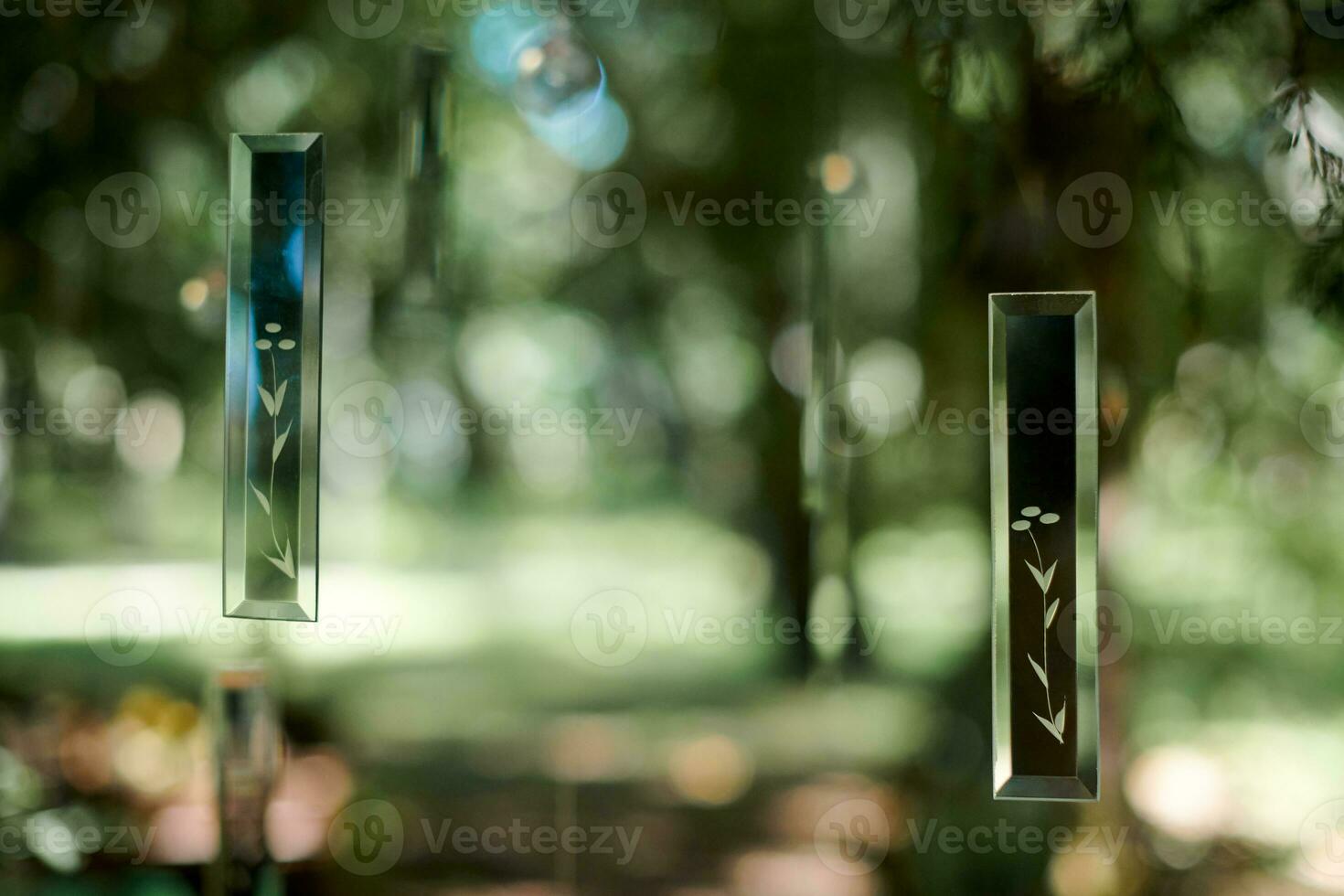 Transparent glass decorative art objects in green forest at outdoor art exhibition photo