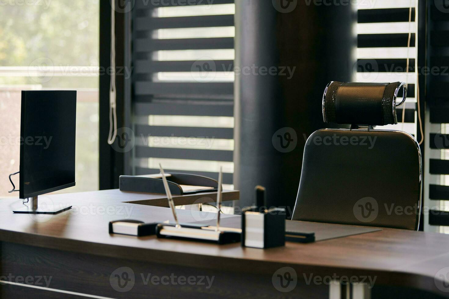 Business office workplace. Work place for chief, boss or other employees. Table and comfortable chair. Light through the half open blinds photo