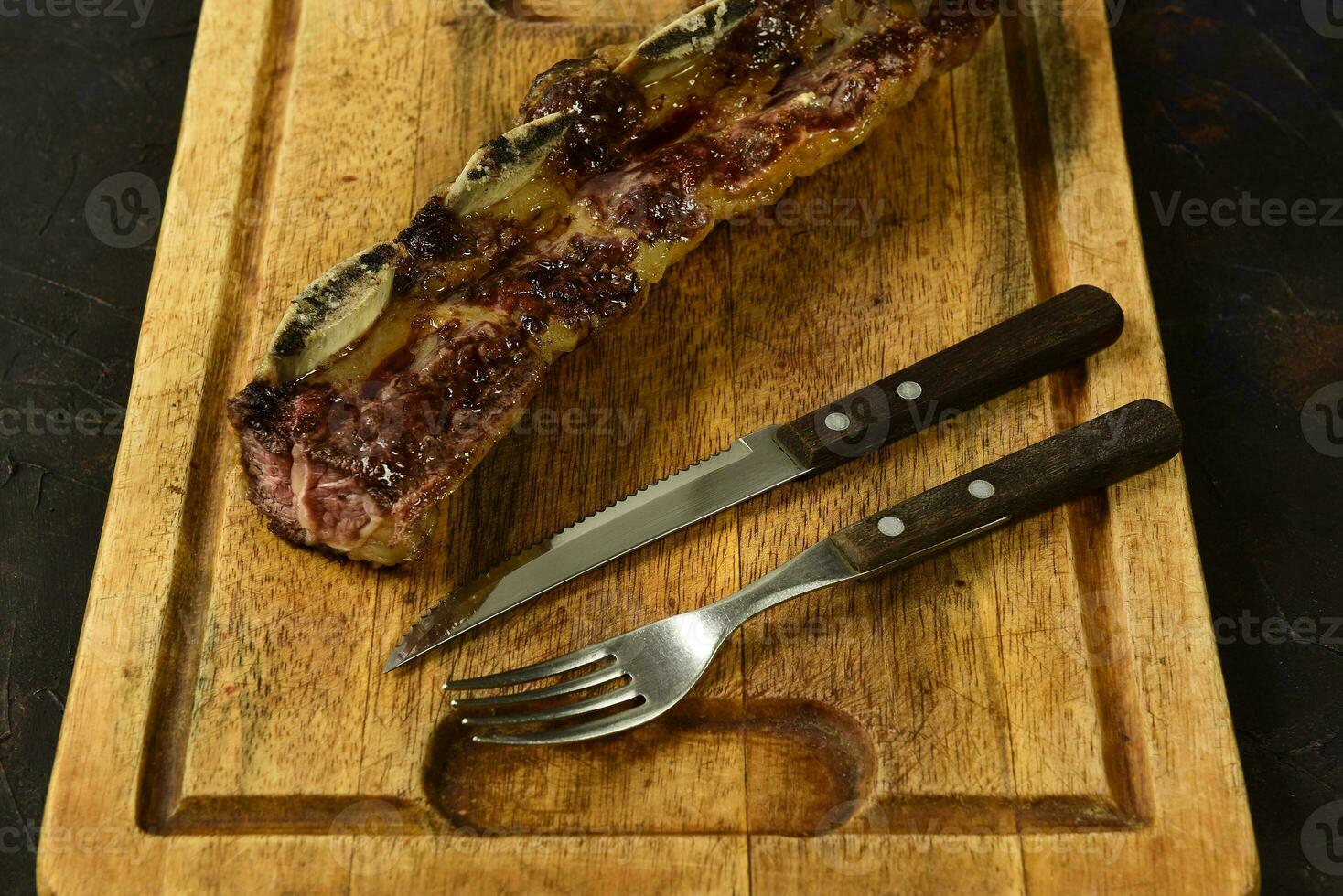 Roasted beef ribs presented on the table, traditional Argentine cuisine, Asado barbecue, Patagonia, Argentina. photo