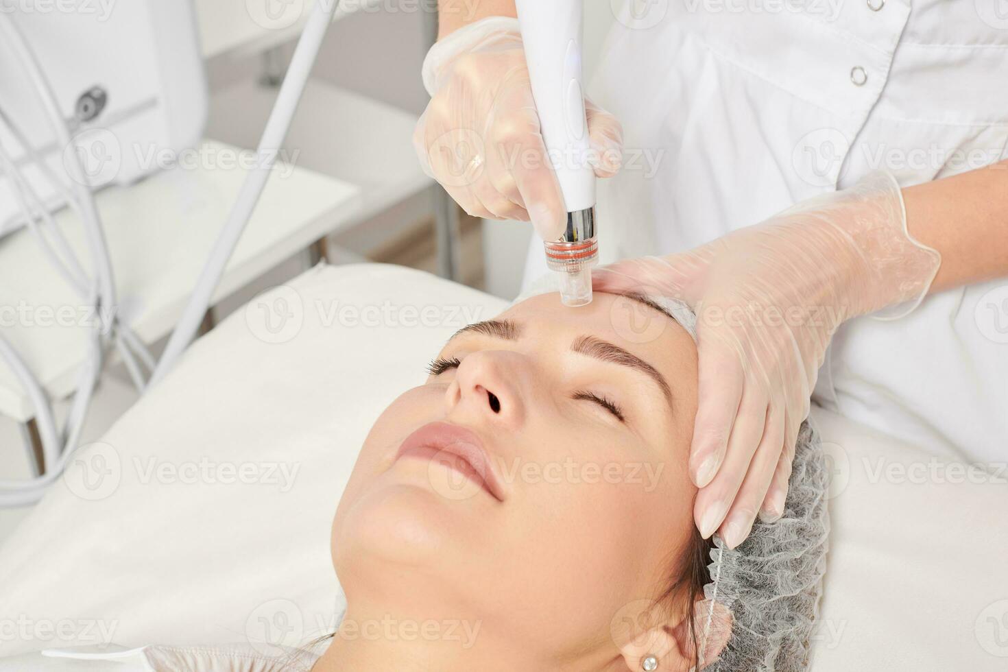 Beautician makes aqua exfoliation for rejuvenation woman face skincare, procedure in beauty salon photo