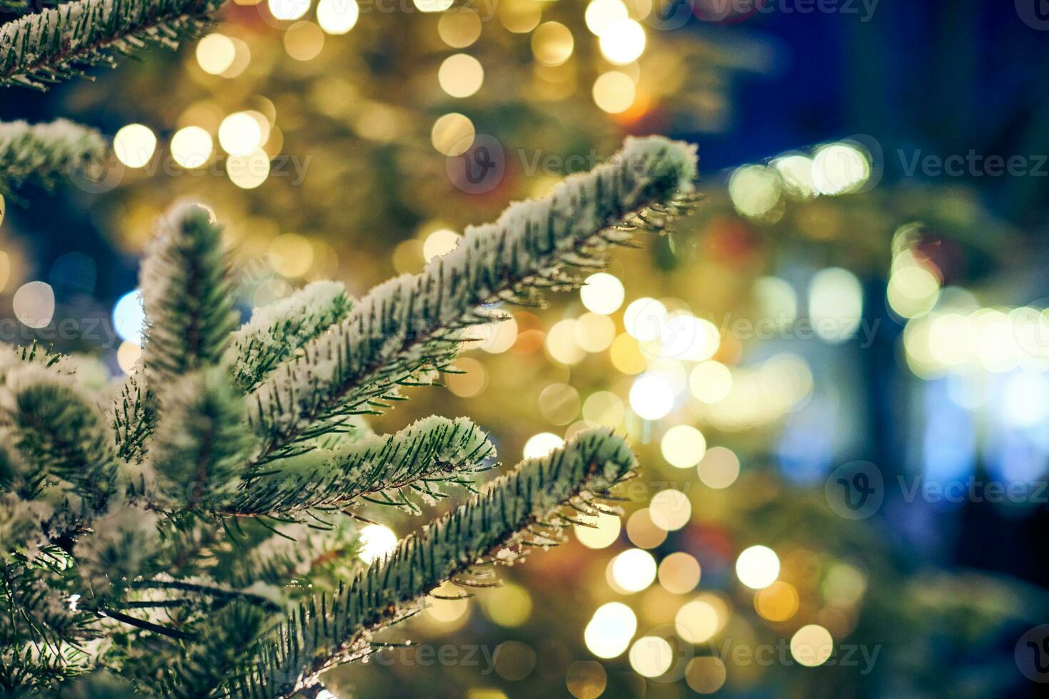 Christmas tree covered snow with yellow garlands lights and bokeh copy space with sparkled bokeh photo