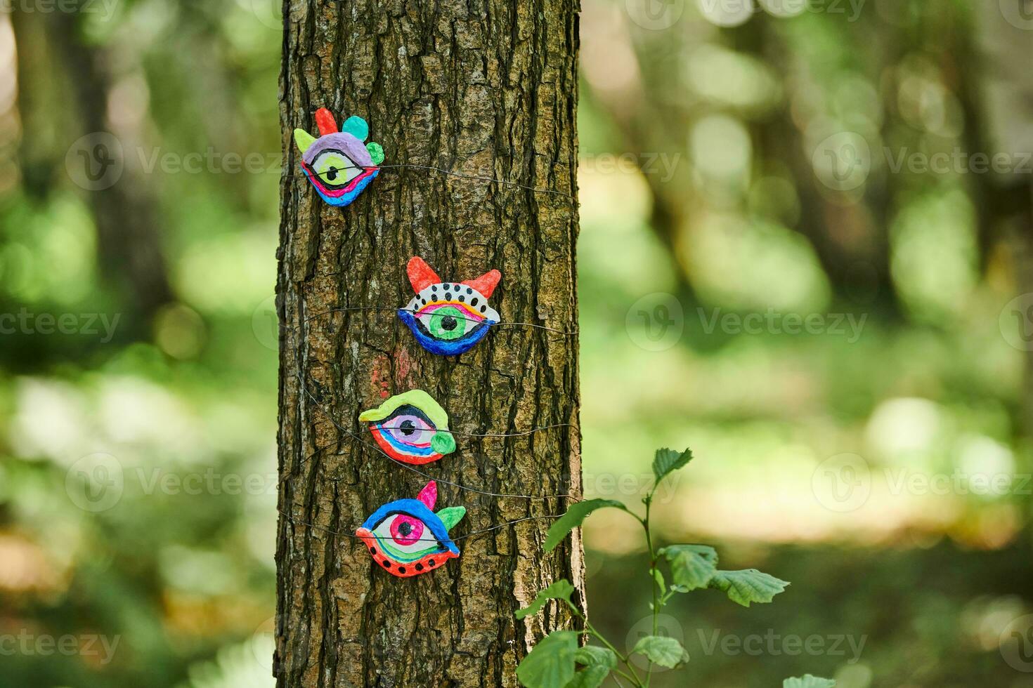 Art object of human eyes on tree trunk in green forest background, trees sight feeling ecological concept photo