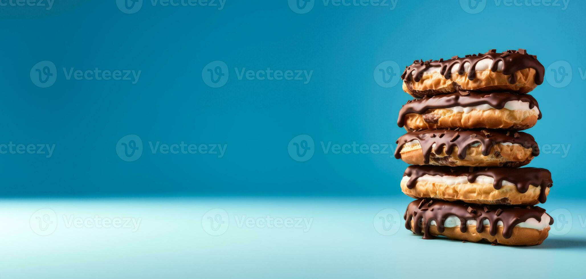Stack of eclairs isolated on vivid background with a copy space, creative concept photo