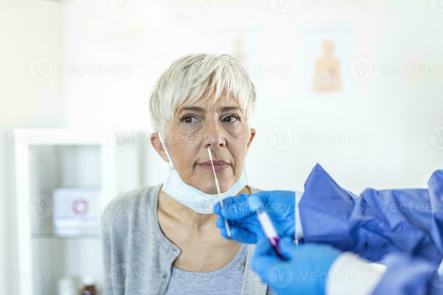 Doctor laboratory assistant in protective suit takes swab from nose of sick patient at hospital. Laboratory tests for coronavirus concept. photo