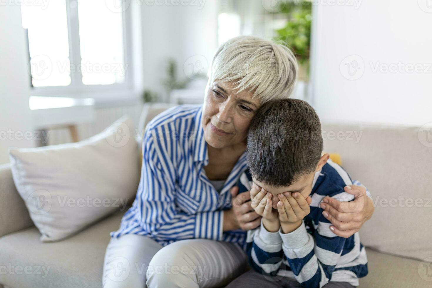 Loving understanding old grandma embracing little crying boy comforting upset grandson, senior caring grandmother hugging child consoling kid in tears, grannys empathy support for grandchild photo