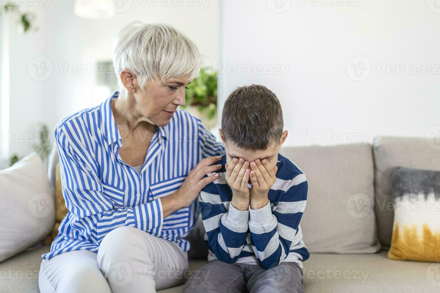 Loving understanding old grandma embracing little crying boy comforting upset grandson, senior caring grandmother hugging child consoling kid in tears, grannys empathy support for grandchild photo