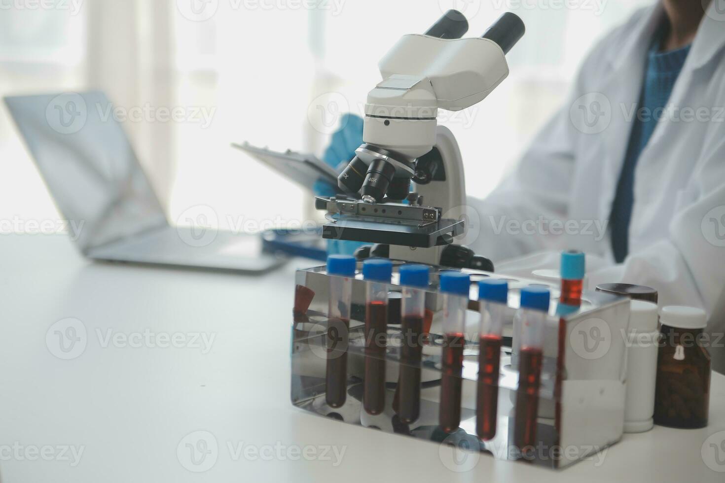 Professional lab. Amazing longhaired medical worker wearing uniform while using microscope during research photo