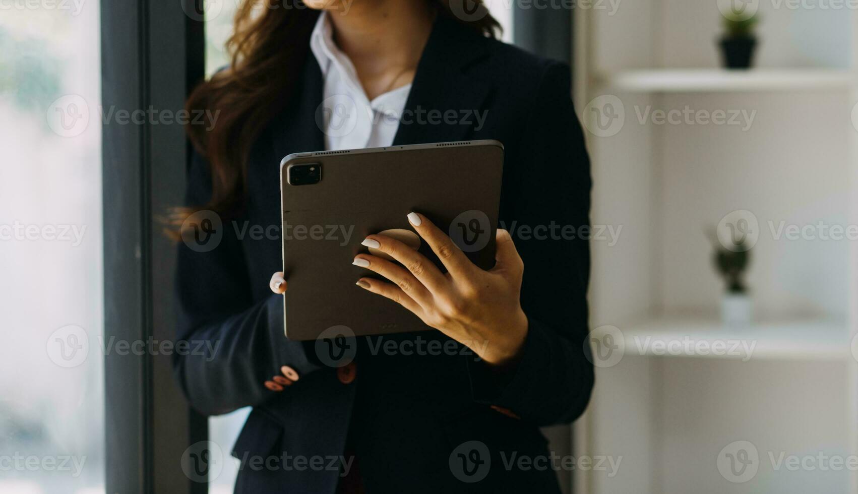 Asian Business woman using calculator and laptop for doing math finance on an office desk, tax, report, accounting, statistics, and analytical research concept photo