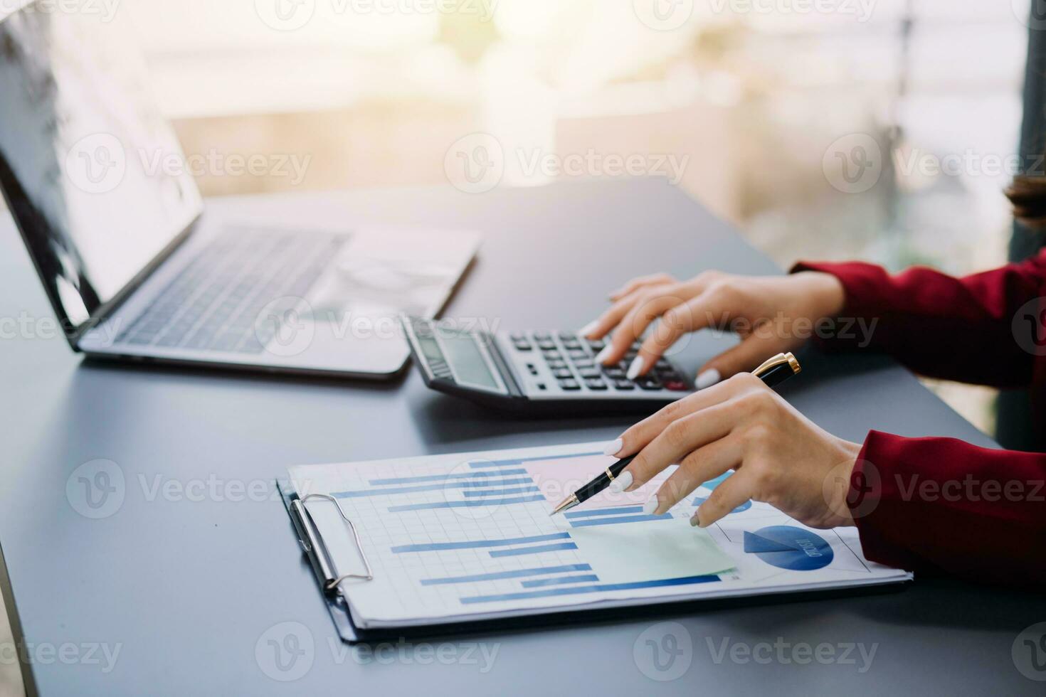 Asian Business woman using calculator and laptop for doing math finance on an office desk, tax, report, accounting, statistics, and analytical research concept photo