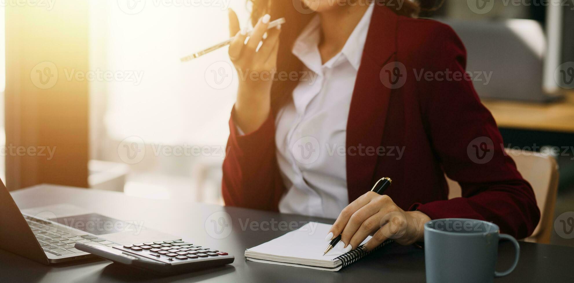 Asian Business woman using calculator and laptop for doing math finance on an office desk, tax, report, accounting, statistics, and analytical research concept photo