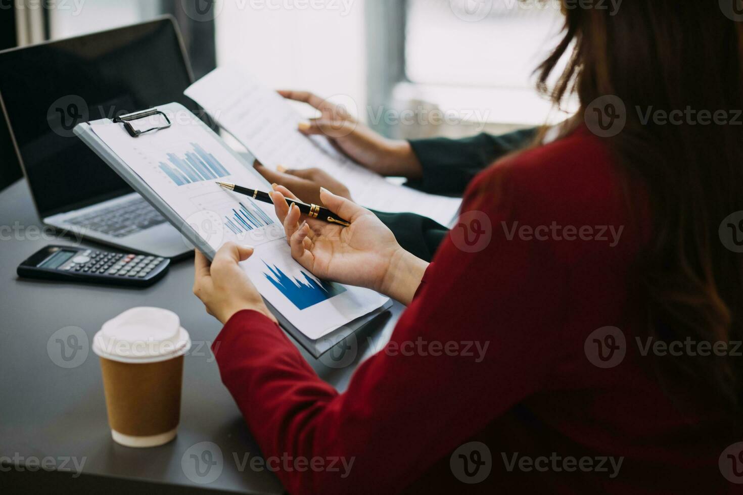 Asian Business woman using calculator and laptop for doing math finance on an office desk, tax, report, accounting, statistics, and analytical research concept photo