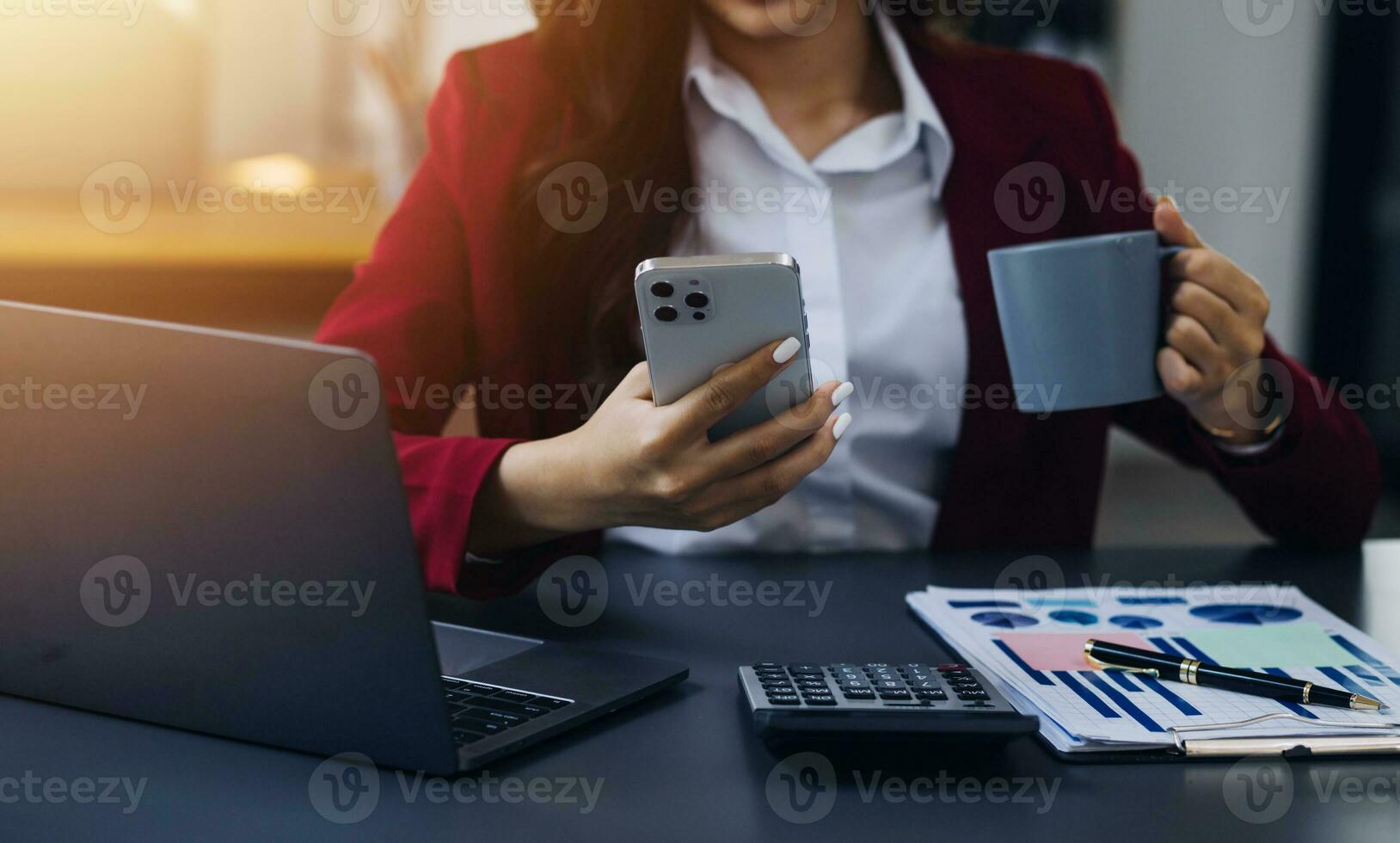 Asian Business woman using calculator and laptop for doing math finance on an office desk, tax, report, accounting, statistics, and analytical research concept photo