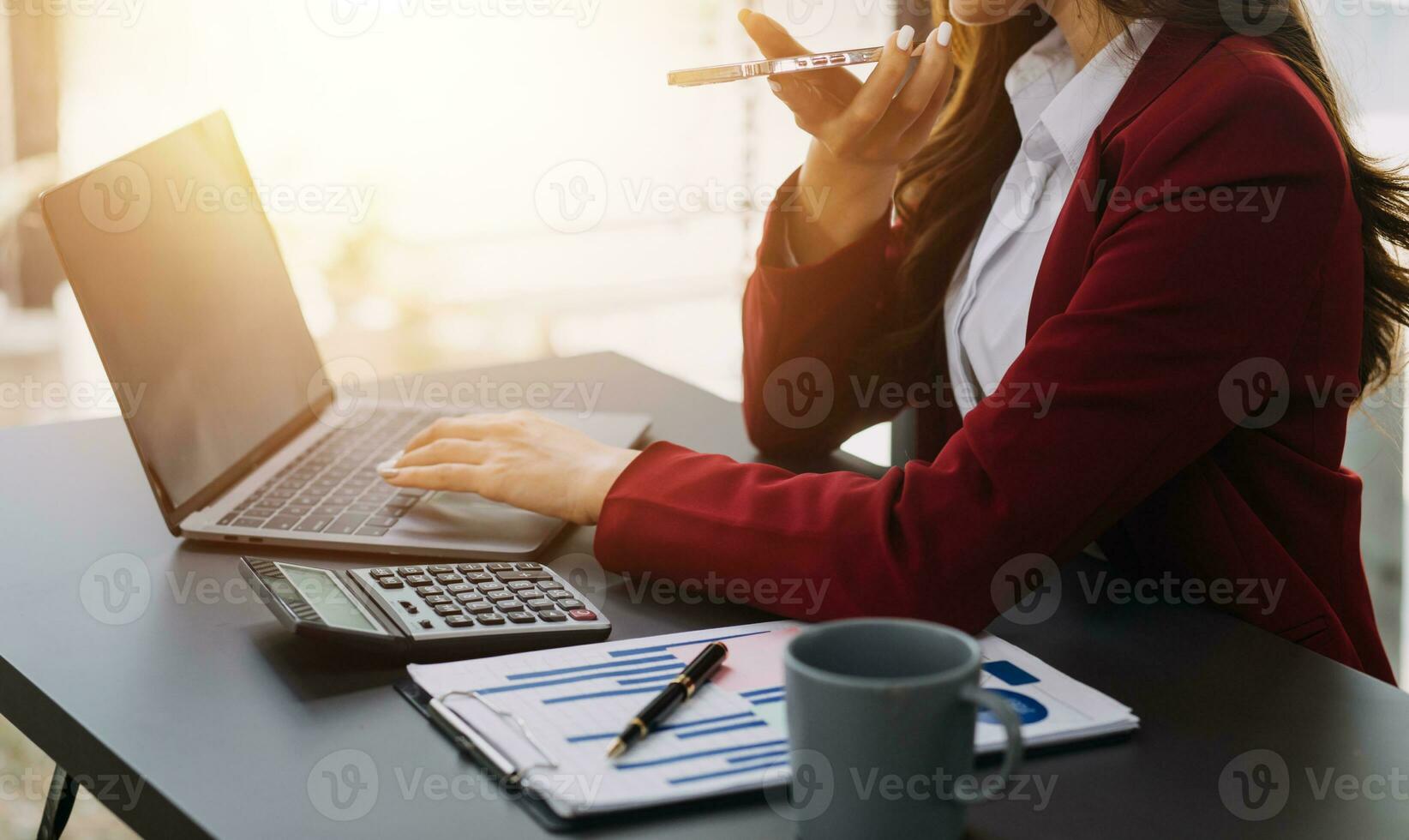 Asian Business woman using calculator and laptop for doing math finance on an office desk, tax, report, accounting, statistics, and analytical research concept photo