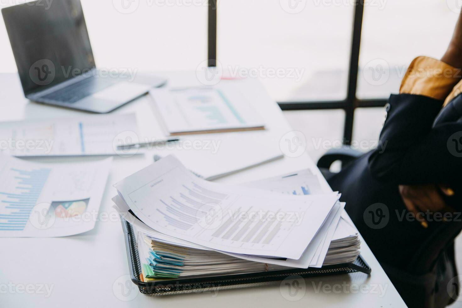 Asian Business woman using calculator and laptop for doing math finance on an office desk, tax, report, accounting, statistics, and analytical research concept photo