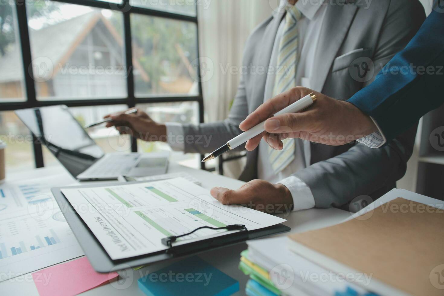 Financial analysts analyze business financial reports on a digital tablet planning investment project during a discussion at a meeting of corporate showing the results of their successful teamwork. photo