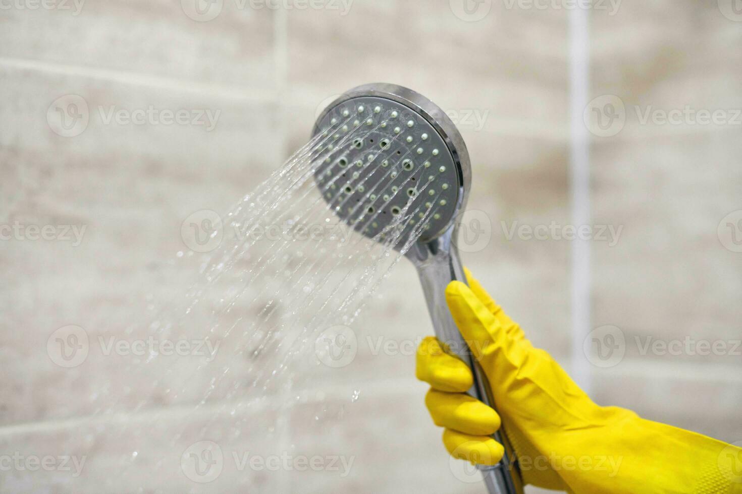 Female hand holds shower head with pouring water, copy space photo