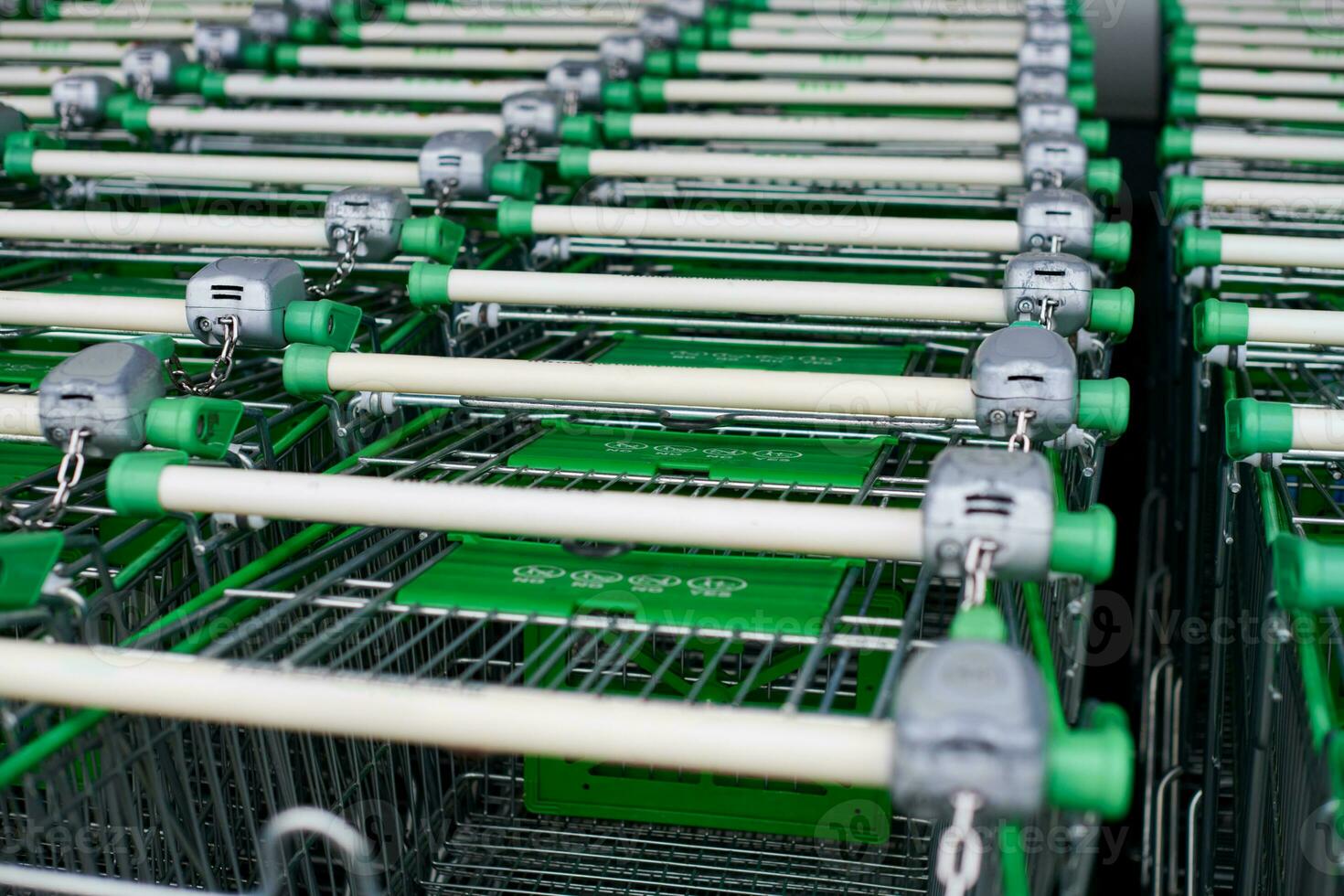 Row of parked shopping carts of trolleys in supermarket photo
