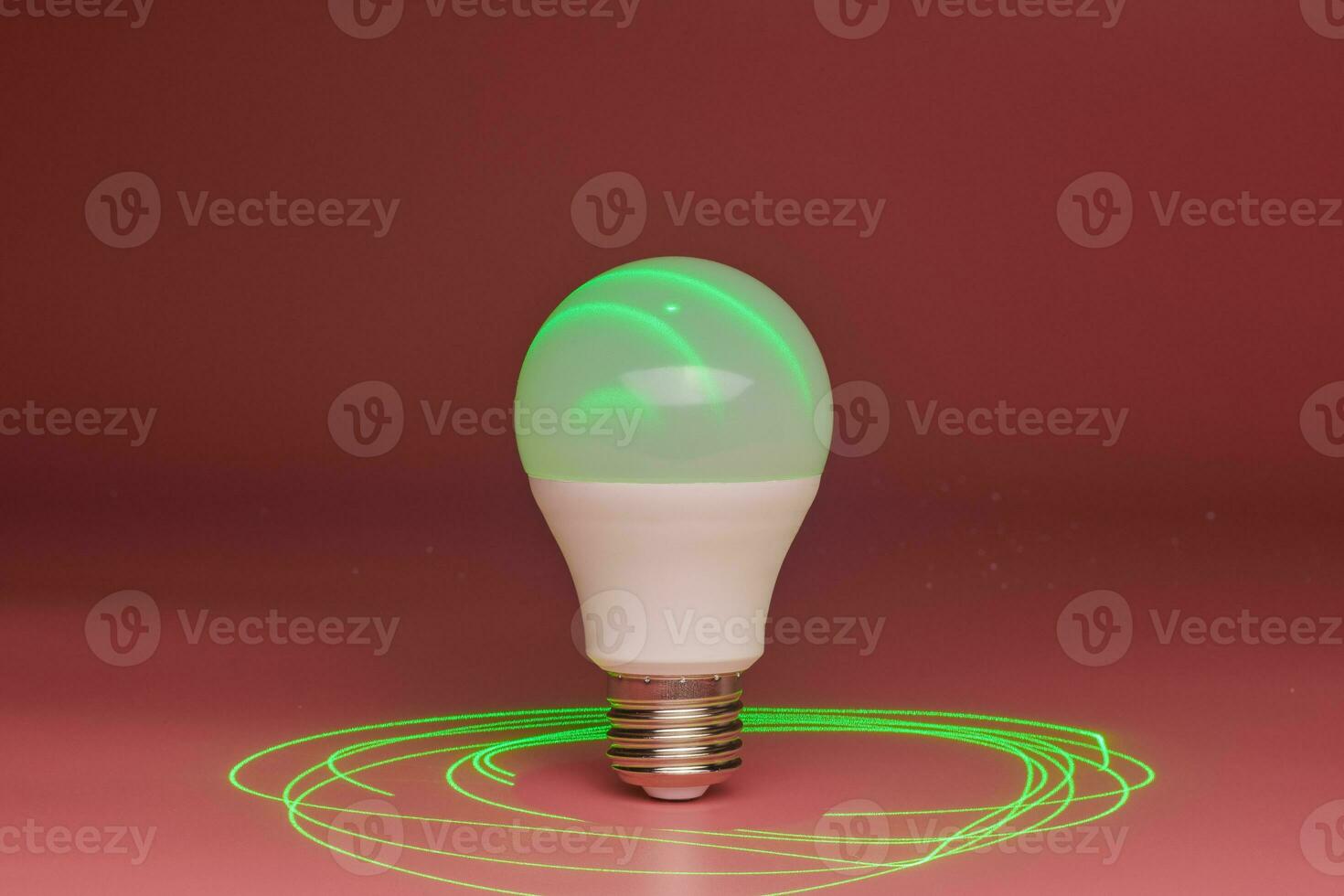 Energy saving light bulb, green laser beam around, copy space. Minimal idea concept. photo