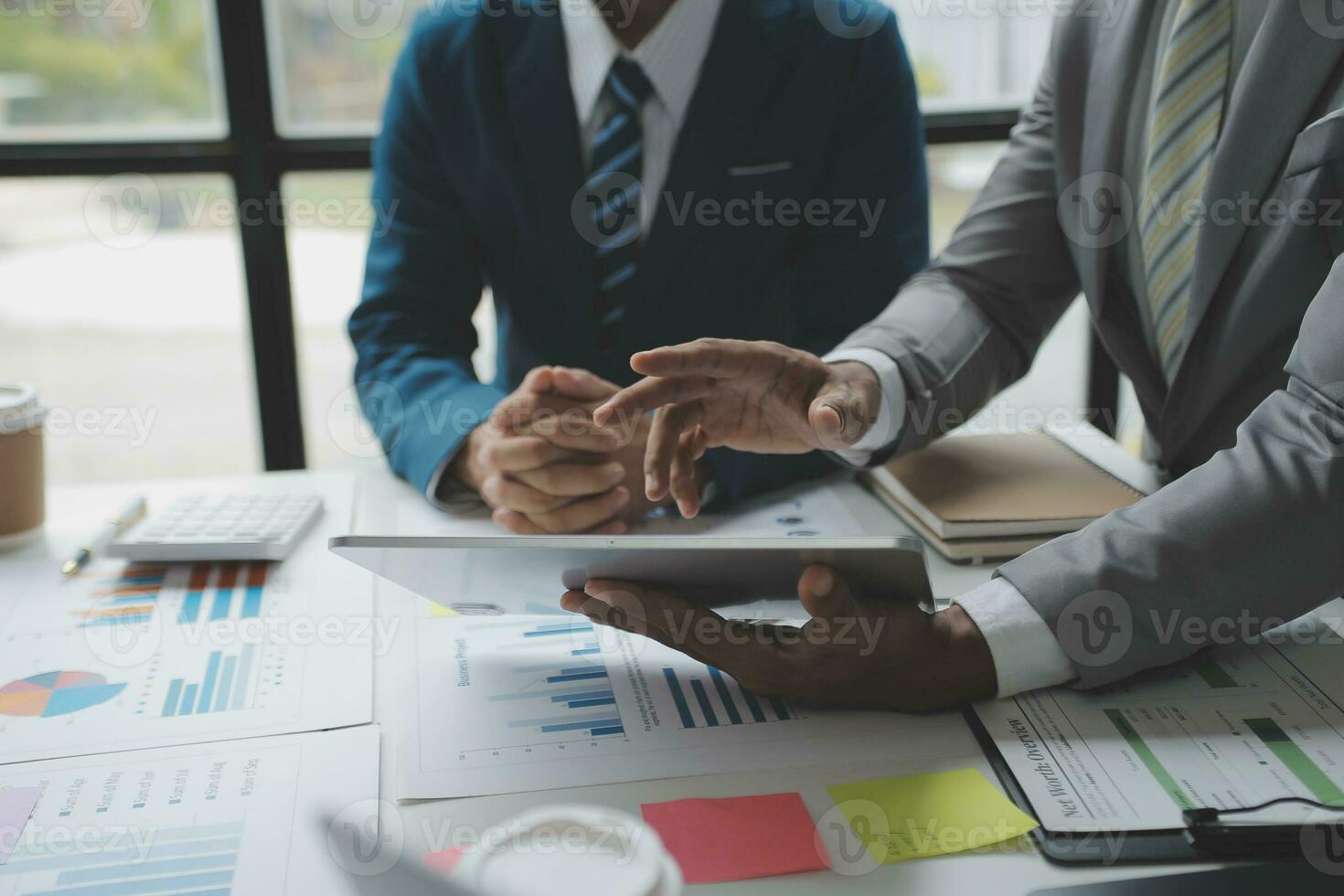 Financial analysts analyze business financial reports on a digital tablet planning investment project during a discussion at a meeting of corporate showing the results of their successful teamwork. photo