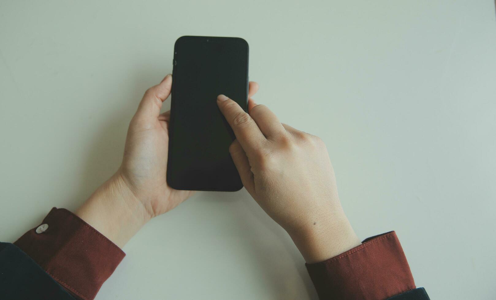 Excited happy Asian woman looking at the phone screen, celebrating an online win, overjoyed young asian female screaming with joy, isolated over a white blur background photo