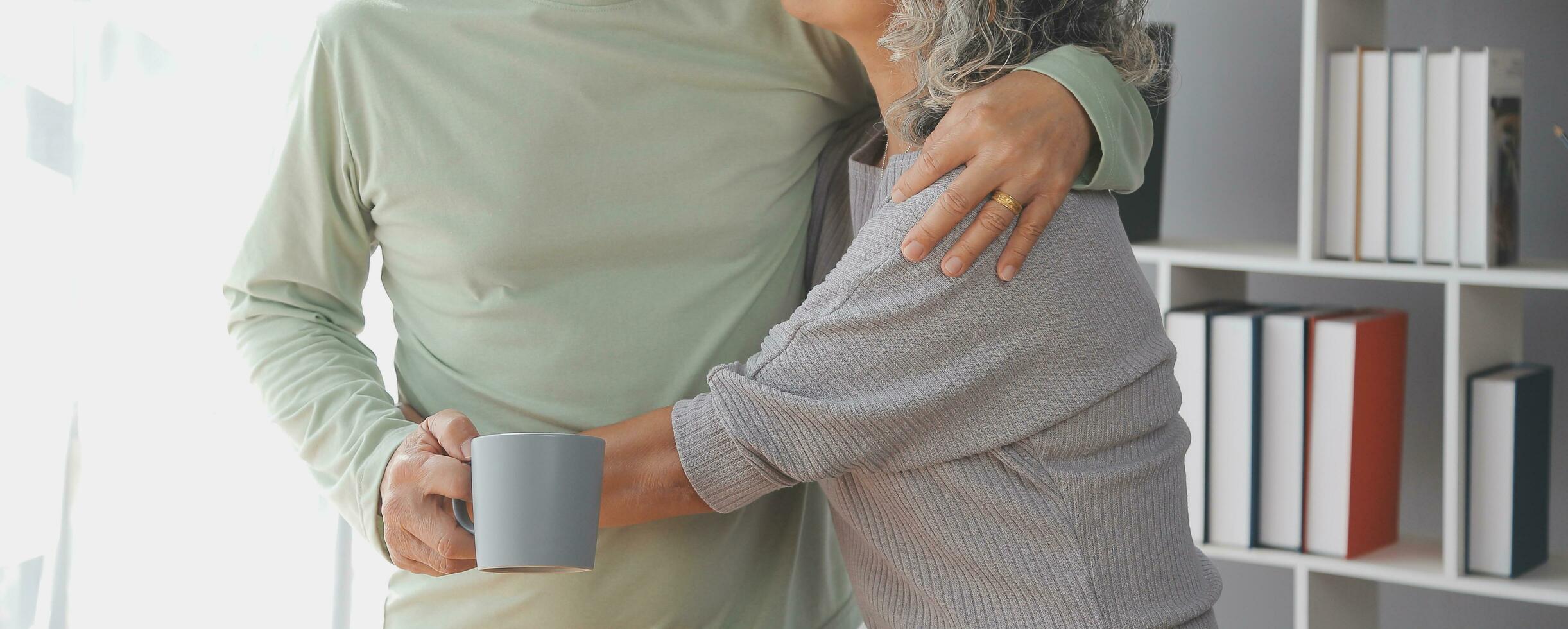 Embraced mature couple surfing the Internet on laptop at home photo