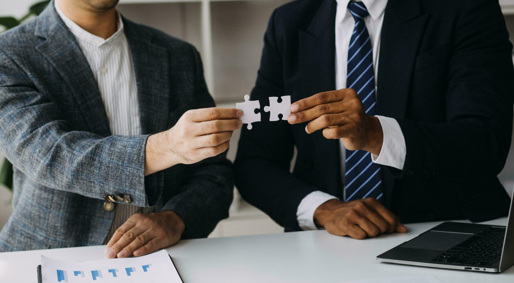 Image of business partners handshaking over business objects on workplace photo