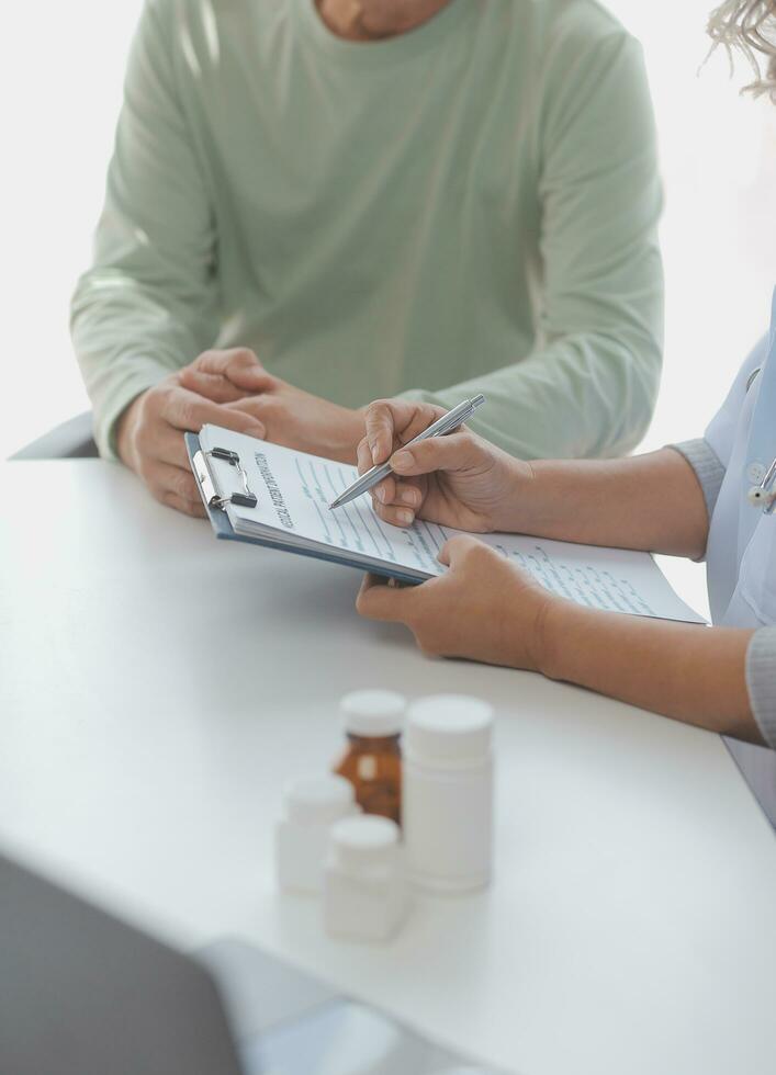 Doctor giving hope. Close up shot of young female physician leaning forward to smiling elderly lady patient holding her hand in palms. Woman caretaker in white coat supporting encouraging old person photo