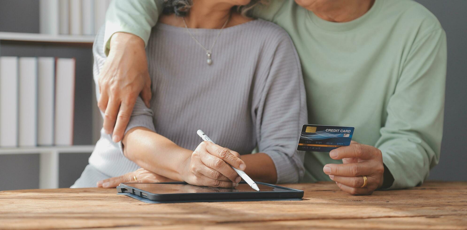 Shocked aged couple become victims of online fraud using credit card phone to pay for goods order service online on suspicious website. Frustrated older spouses overspending money at internet shopping photo