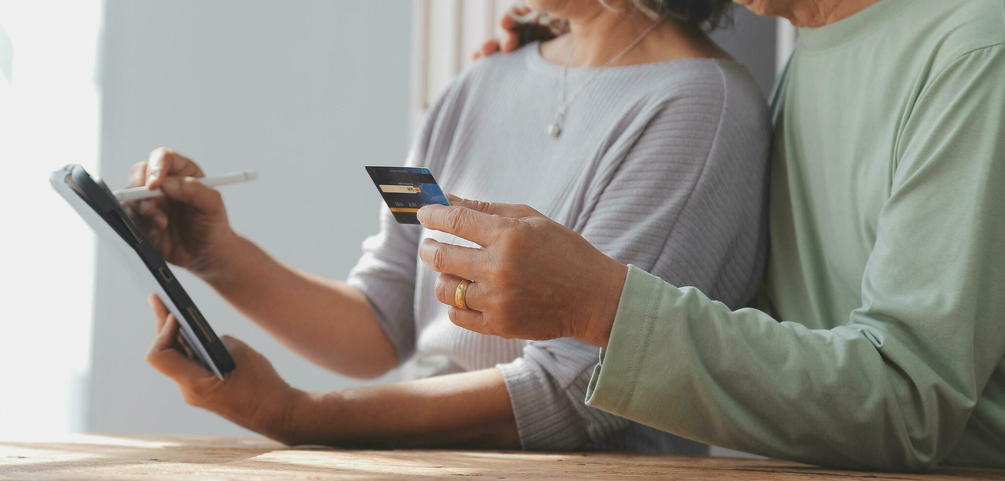 Shocked aged couple become victims of online fraud using credit card phone to pay for goods order service online on suspicious website. Frustrated older spouses overspending money at internet shopping photo