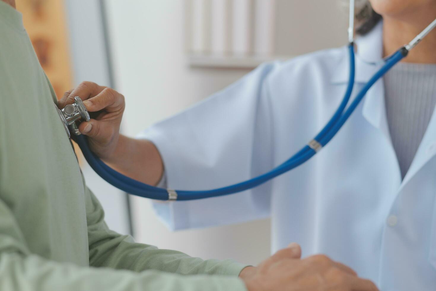 Doctor giving hope. Close up shot of young female physician leaning forward to smiling elderly lady patient holding her hand in palms. Woman caretaker in white coat supporting encouraging old person photo