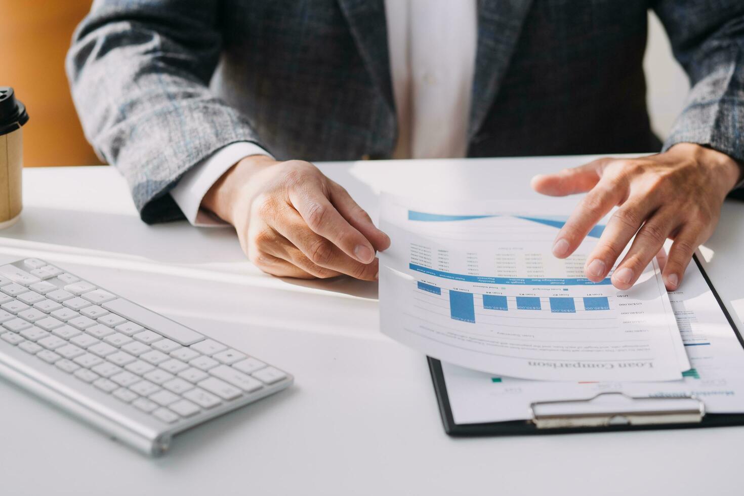 Image of business partners handshaking over business objects on workplace photo