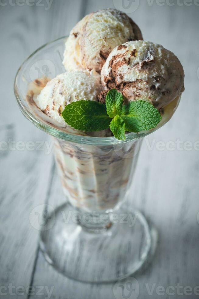 vainilla-chocolate hielo crema en un helado con frutas y nueces vaso foto